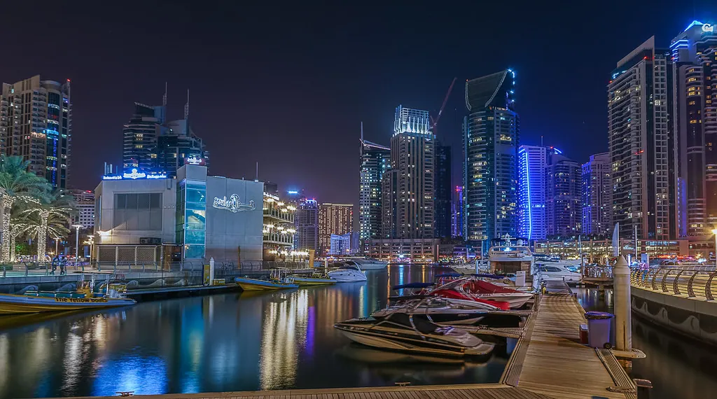 Dubai Marina towers glowing over the water at night