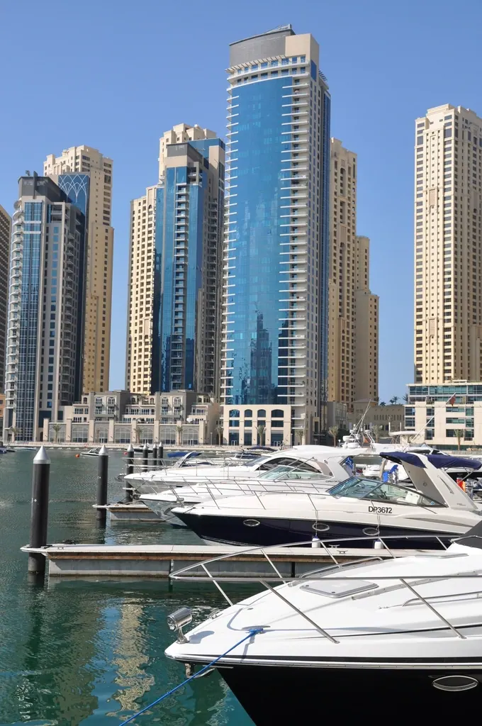 White yachts docked below Dubai Marina towers